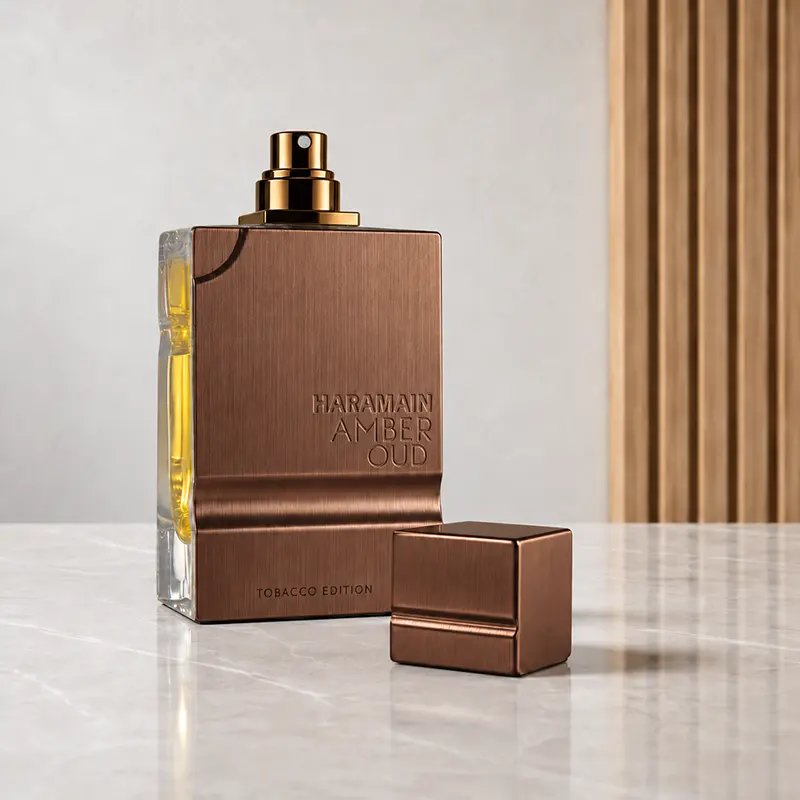 Amber Oud Tobacco Edition bottle with cap removed, showing the gold atomiser and detached cap.