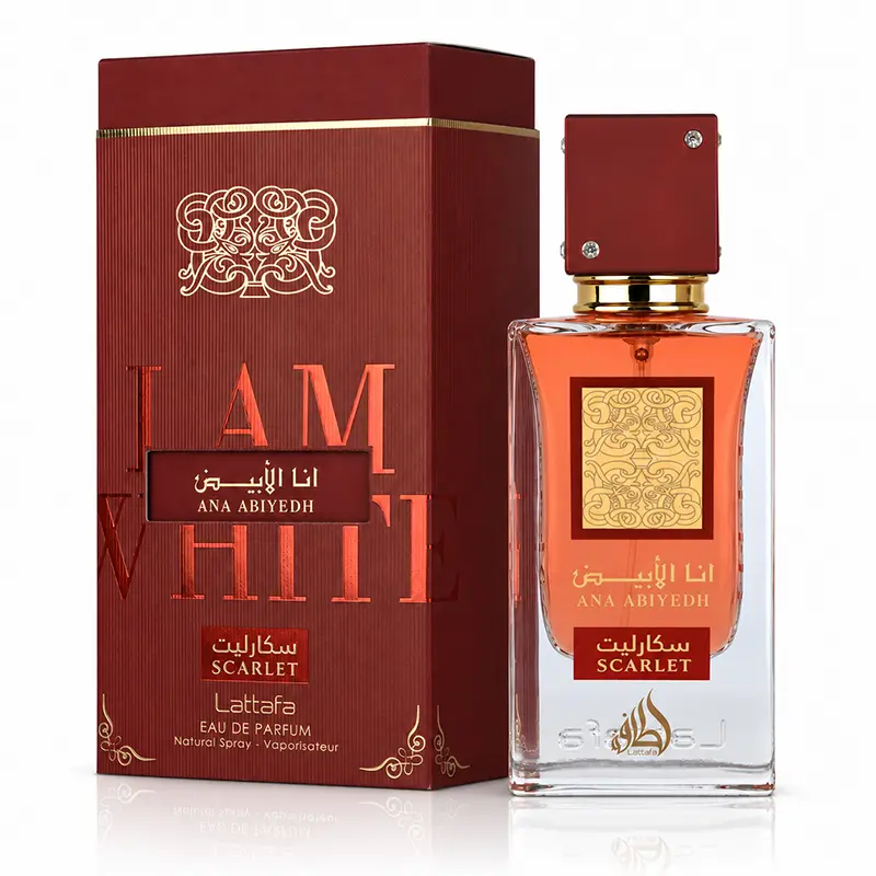 A Lattafa Ana Abiyedh Scarlet perfume bottle and matching red box arranged together on a reflective surface.