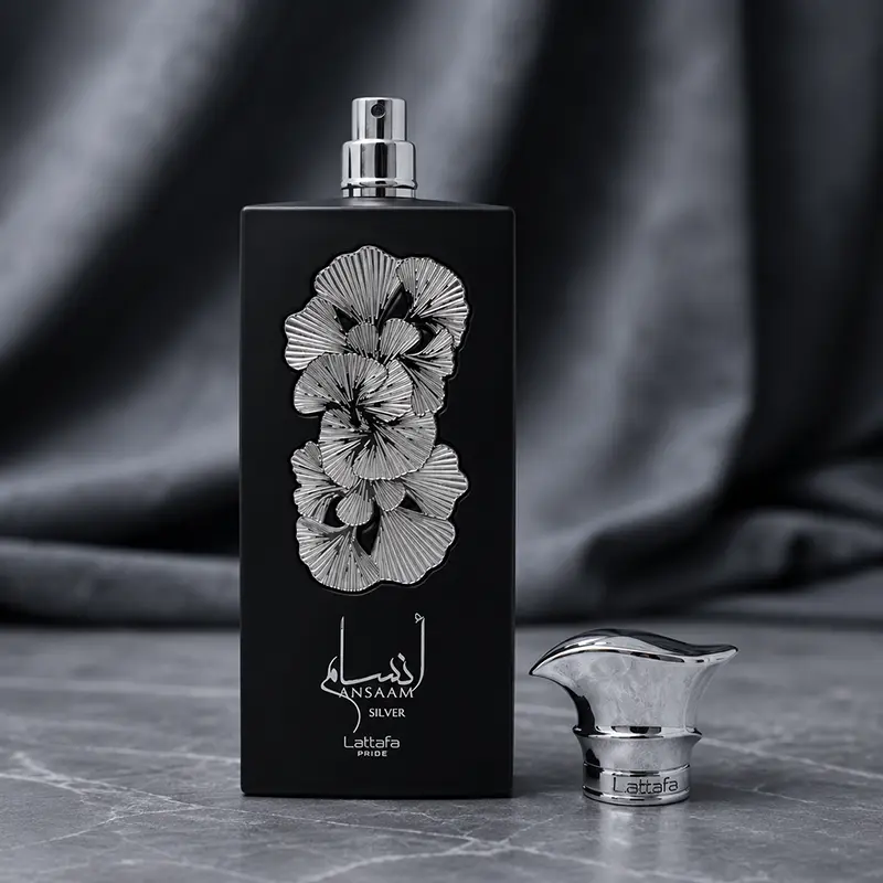 Matte black perfume bottle showcasing the silver metallic spray nozzle alongside its uniquely shaped reflective cap.