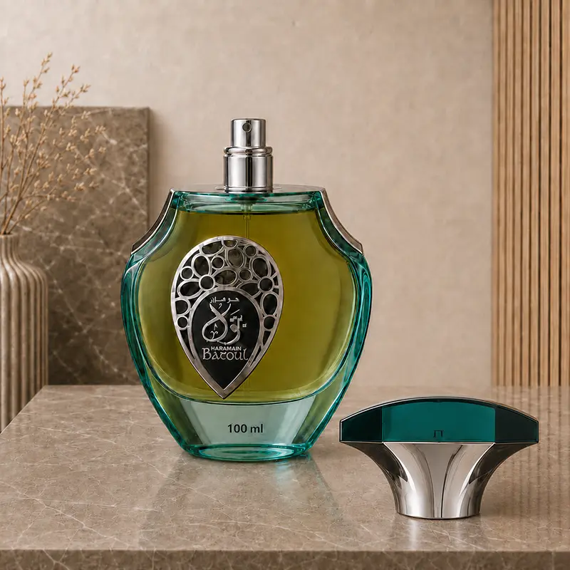 Uncapped Batoul 100ml bottle shows the silver spray nozzle beside its teal and chrome cap.