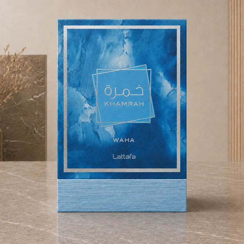 Blue Khamrah Waha box shown front-facing with silver trim, layered square artwork and an aqua base.