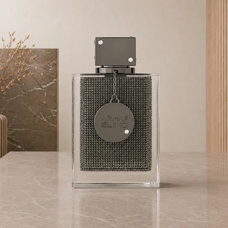 Armaf Club de Nuit Bling bottle shown front-facing with its square studded cap and circular hanging charm