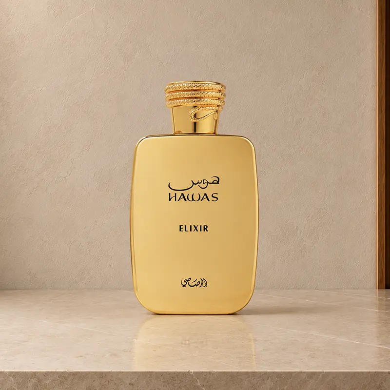 Gold Hawas Elixir bottle with cap fitted, displayed upright on a light stone surface.