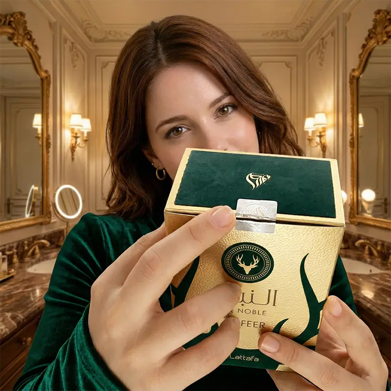 Close-up of hands holding and opening the textured gold and green velvet top of the unboxing experience for the fragrance.