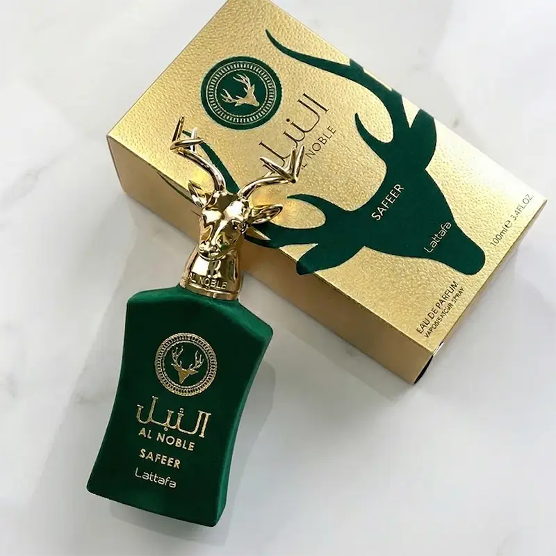 High-angle shot showing the distinctive green velvet bottle with a golden deer cap resting against its gold and green textured box and bottle.