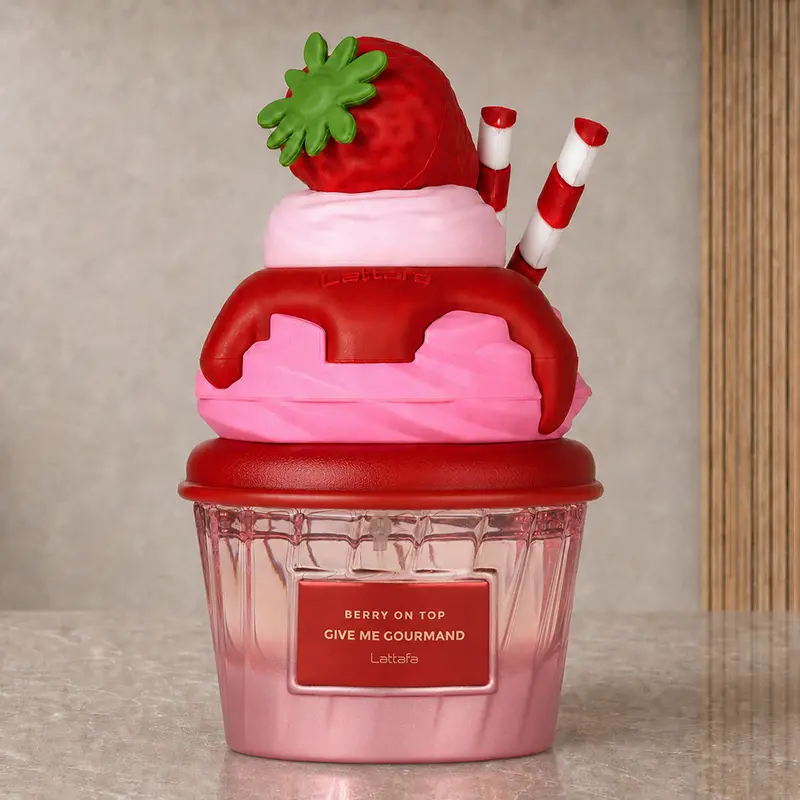 Lattafa Berry on Top bottle with a pink dessert-shaped cap, strawberry and striped decorations