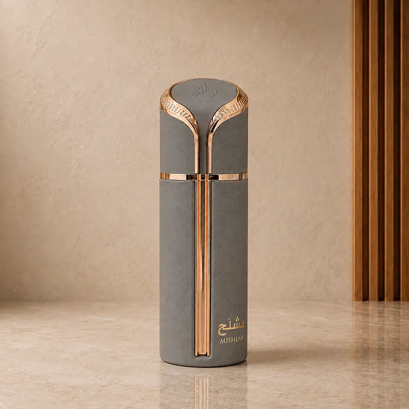 Lattafa Mishlah grey perfume bottle with gold-toned trim on a stone surface.