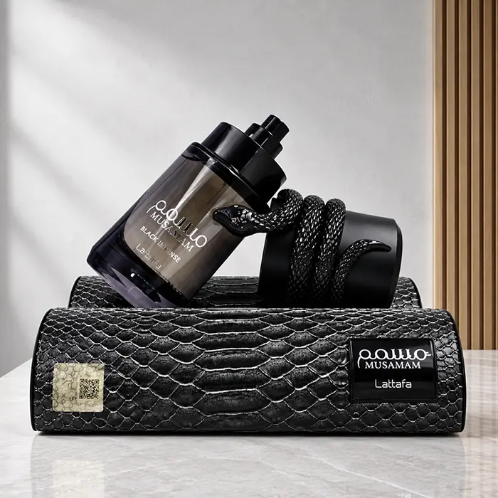 Musamam Black Intense bottle with exposed atomiser and detached snake-wrapped cap resting on its presentation case.