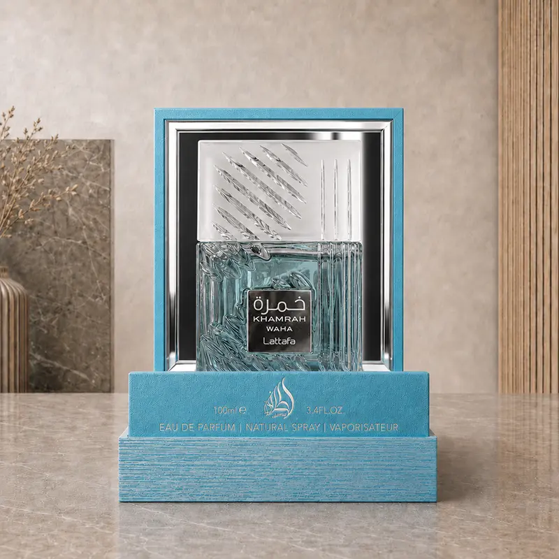 Open turquoise presentation box holding the Khamrah Waha bottle against a reflective silver inner panel.