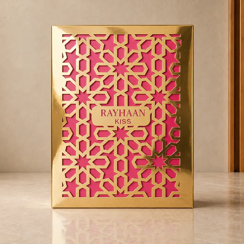 Rayhaan Kiss perfume box in front view with reflective gold lattice over a pink panel.