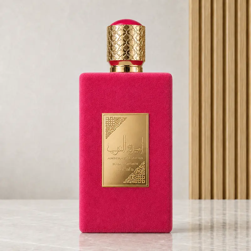 Pink Lattafa Sugar Crown bottle with a gold-coloured plaque and patterned cap on a reflective studio surface