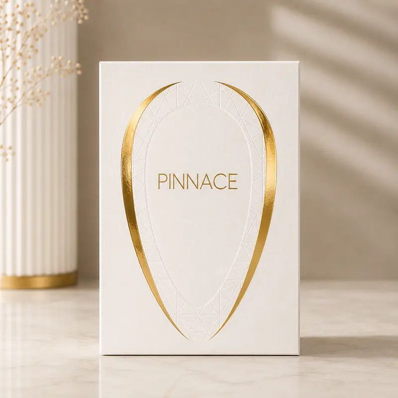 Front-facing Pinnace Blanc packaging with textured white surface and metallic gold logo design.