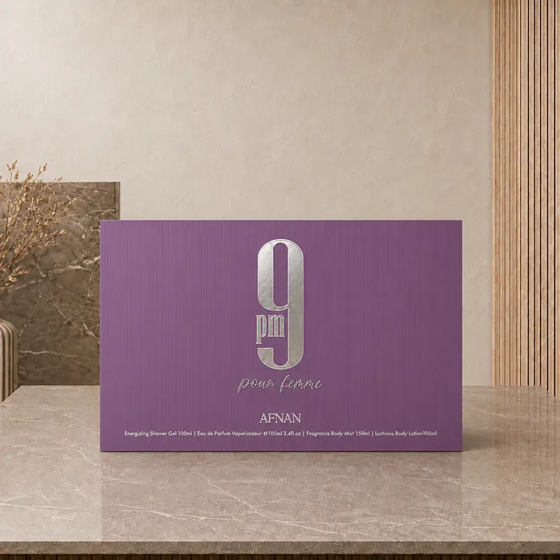 Purple Afnan 9 PM Pour Femme gift-set box displayed on a stone countertop.
