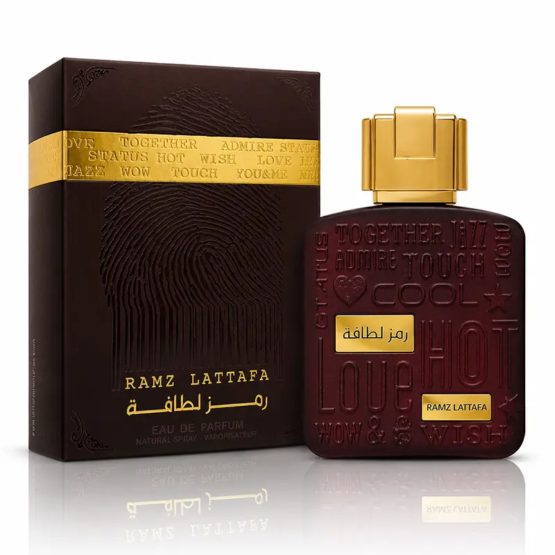 Ramz Lattafa Gold 100ml Eau de Parfum bottle and box on white background with soft reflection.