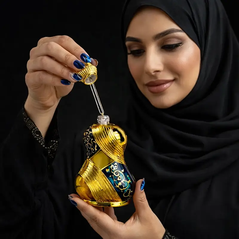 Woman in a black headscarf holding the Raniya bottle with its glass dropper raised.