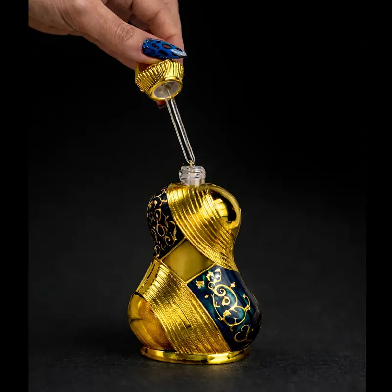 Khadlaj Raniya perfume oil shown open with a glass dropper above the ornate gold bottle.