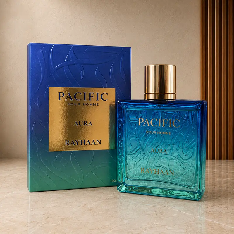 Rayhaan Pacific Aura bottle beside matching box, both shown at a slight angle on a stone surface.