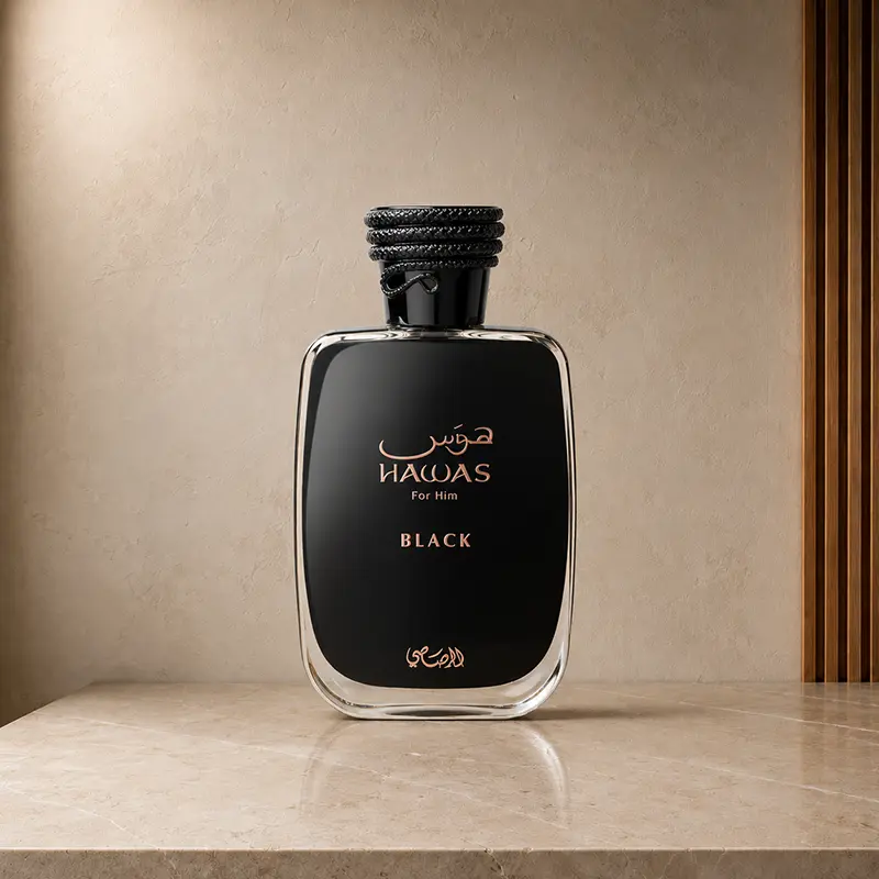 Hawas Black For Him bottle with rose-gold lettering on a cream stone platform.
