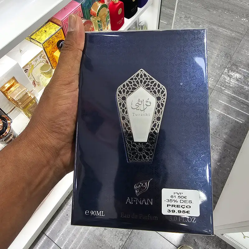 Sealed navy Afnan Turathi Blue 90 ml Eau de Parfum box held inside a perfume shop.