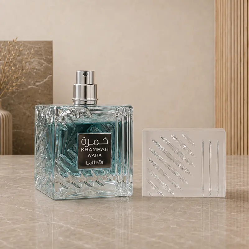 Removed frosted cap reveals the silver atomizer on the textured aqua Khamrah Waha perfume bottle.