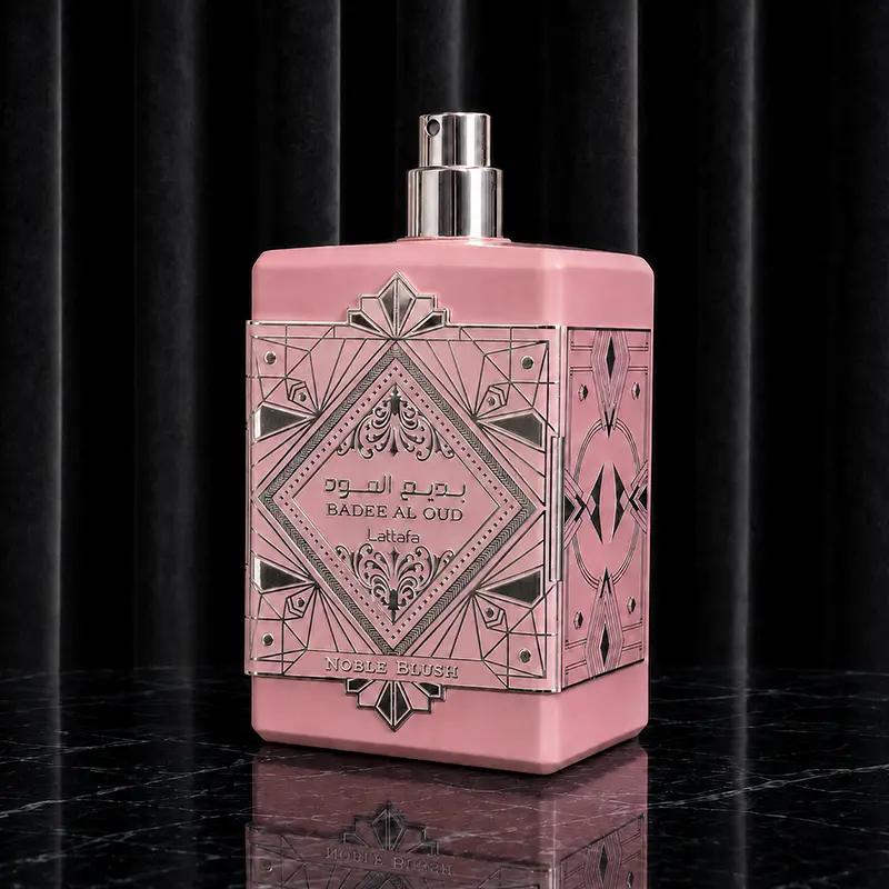 Angular closeup view of the pink matte bottle showcasing its silver geometric metal plate and uncovered shiny silver atomizer.