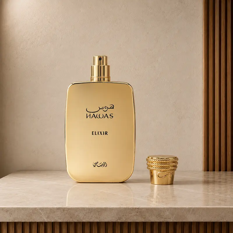Hawas Elixir gold bottle with spray nozzle exposed and decorative cap placed beside it.