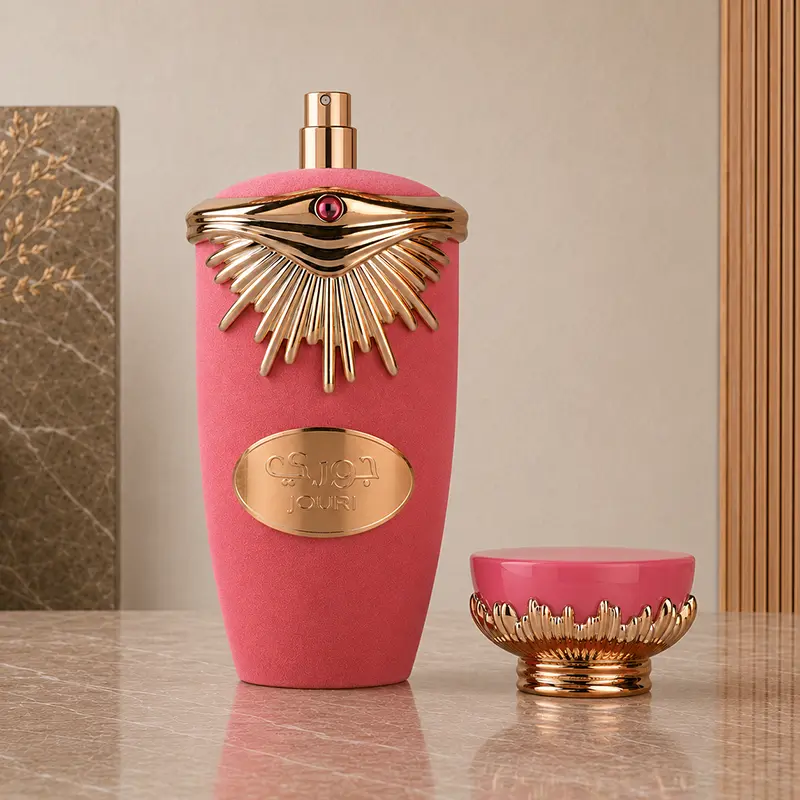 Exposed spray nozzle on the Lattafa Jouri bottle with its pink and gold decorative cap placed beside it.