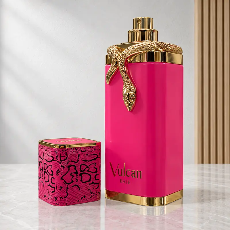 Uncapped Vulcan Baie bottle showing the gold-coloured atomiser beside its pink and black patterned cap.